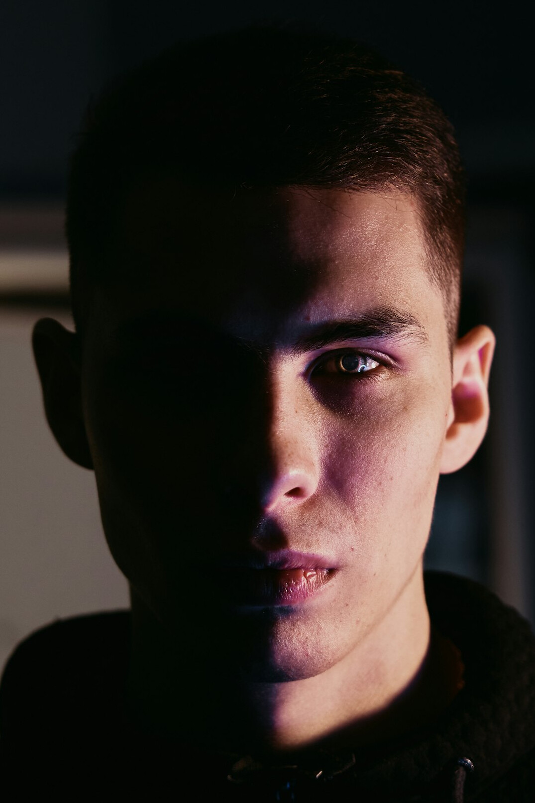 Portrait of a young man with short hair looking at camera